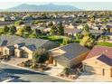 Aerial view of single-story home with desert landscaping, mountain backdrop, and surrounding neighborhood at 42906 W Darter Dr, Maricopa, AZ 85138