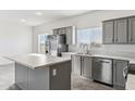 Modern kitchen with gray cabinets, stainless steel appliances, and an island at 53275 W Adele Rd, Maricopa, AZ 85139