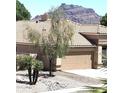Charming single-story home with a two-car garage, desert landscaping, and a mountain view at 5951 E Trailridge St, Mesa, AZ 85215