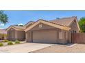 View of the two-car garage and low maintenance front yard at 1231 W Hawken Way, Chandler, AZ 85286