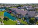 Aerial view showcasing a community of homes situated around a lake at 15091 N 90Th Dr, Peoria, AZ 85381