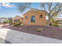 Tan stucco home with mature trees and drought-tolerant landscaping at 26487 W Runion Dr, Buckeye, AZ 85396