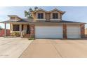 Two-story house with a brick facade, three-car garage, and landscaped front yard at 8934 W Ocotillo Rd, Glendale, AZ 85305