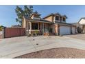 Two-story house with a brick facade, three-car garage, and gate at 8934 W Ocotillo Rd, Glendale, AZ 85305