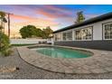 Inviting oval pool with surrounding stone patio and fire pit at 1302 W Golden Ln, Phoenix, AZ 85021