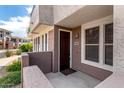 Welcoming front entrance with dark wood door, neutral stucco, and verdant landscape at 15221 N Clubgate Dr # 1110, Scottsdale, AZ 85254