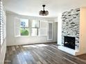 Bright living room with wood floors, modern fireplace, plantation shutters, and contemporary ceiling fan at 15221 N Clubgate Dr # 1110, Scottsdale, AZ 85254