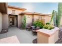 Front entry with seating area, mature plants, and decorative stone at 19425 N Guardian Ln, Surprise, AZ 85387