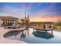 Stunning pool and spa with a unique design, surrounded by desert landscaping at 27432 N 66Th Way, Scottsdale, AZ 85266
