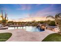 Expansive pool with waterfall feature, spa, and inviting pergola; perfect for entertaining at 27432 N 66Th Way, Scottsdale, AZ 85266