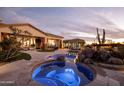 Luxurious spa with blue lighting nestled in a beautifully landscaped backyard at 27432 N 66Th Way, Scottsdale, AZ 85266