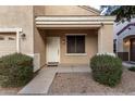 Front entry with a light brown door and bushes on either side at 1410 E Dunbar Dr, Phoenix, AZ 85042