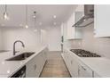 Modern kitchen with white cabinets, gas cooktop and quartz countertops at 24045 N 172Nd Ave, Surprise, AZ 85387