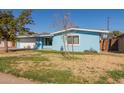 Ranch style home with light blue exterior, landscaped lawn and attached garage at 1054 E 2Nd Pl, Mesa, AZ 85203