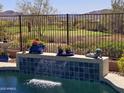 Backyard pool featuring a water feature, golf course view and iron fence at 41716 N Laurel Valley Way, Anthem, AZ 85086