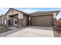 Beautiful new home with stone accents on the pillars and a wide driveway leading to a two car garage at 7641 W Minton St, Laveen, AZ 85339