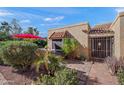 Front entry with tile patio, red umbrella, and lush landscaping at 1066 E Clinton St, Phoenix, AZ 85020