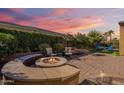 Landscaped backyard with a fire pit and seating area at 1351 E Artemis Trl, Queen Creek, AZ 85140