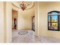 Elegant foyer showcasing a decorative tile inlay, decorative light fixture and wrought iron door at 16149 E Thistle Dr, Fountain Hills, AZ 85268