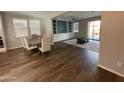 Open concept living room with hardwood floors, a dining area, and a custom built-in entertainment center at 1669 S Wallrade Ln, Gilbert, AZ 85295