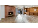 Bright living room with a brick fireplace, wood shelving, and tile floors at 1905 W Cambridge Ave, Phoenix, AZ 85009