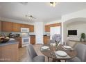 Bright kitchen featuring wood cabinets, white appliances, and a cozy dining area at 22814 W Cantilever St, Buckeye, AZ 85326