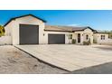 New construction home with a modern design, featuring a large driveway and three-car garage at 2917 N Katie Ln, Litchfield Park, AZ 85340