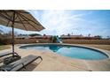 Inviting kidney-shaped pool with patio furniture and umbrella at 3433 W Mescal St, Phoenix, AZ 85029