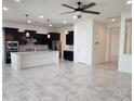 Bright, open kitchen and living room with a spacious island, stylish lighting, and tiled floors at 4866 N 185Th Dr, Goodyear, AZ 85395