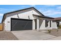 Charming single-story home featuring a gray garage door and complementary desert landscaping at 16590 N Dante Way, Maricopa, AZ 85138