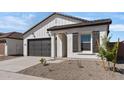 Charming single-story home featuring a gray garage door and complementary desert landscaping at 16590 N Dante Way, Maricopa, AZ 85138