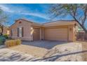 Tan house with a two-car garage and brick driveway at 4219 N 161St Ave, Goodyear, AZ 85395