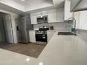 Bright kitchen featuring stainless steel appliances, quartz countertops, and ample cabinet space at 4643 W Laurel Ln, Glendale, AZ 85304