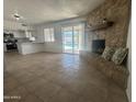 Spacious living room with stone fireplace and a view of the pool through sliding glass doors at 4643 W Laurel Ln, Glendale, AZ 85304