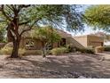 House with mature trees, gravel landscaping, and a two-car garage at 9725 E Windrose Dr, Scottsdale, AZ 85260