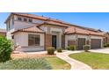 Welcoming home featuring stone accents, a tiled roof, and a well-maintained front yard with mature plants at 135 E Julian Dr, Gilbert, AZ 85295