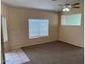 Spacious living room featuring carpeted floors and a large window at 4051 W Buckskin Trl, Phoenix, AZ 85083