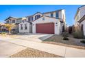 Two-story house with red garage door, desert landscaping, and a driveway at 14271 W Alameda Rd, Surprise, AZ 85387