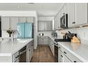 Modern kitchen with gray cabinets, quartz countertops, and stainless steel appliances at 17849 W Thistle Landing Dr, Goodyear, AZ 85338