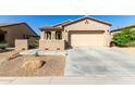 Single-story home with a two-car garage and desert landscaping at 18076 W Nighthawk Way, Goodyear, AZ 85338