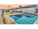 Enjoy this backyard pool with green grass, palm trees, and patio furniture at sunset at 3807 N 87Th St, Scottsdale, AZ 85251