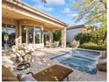 Relaxing backyard with a sparkling pool, patio furniture, and lush landscaping at 10671 E Caribbean Ln, Scottsdale, AZ 85255