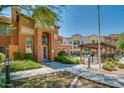 Beautiful condo building with manicured landscaping and walkway leading to a pool area at 14575 W Mountain View Blvd # 11317, Surprise, AZ 85374