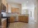 Kitchen boasts stainless steel appliances, tile backsplash, and granite countertops at 14575 W Mountain View Blvd # 11317, Surprise, AZ 85374