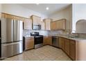 Bright kitchen features stainless steel appliances, tile backsplash, and granite countertops at 14575 W Mountain View Blvd # 11317, Surprise, AZ 85374