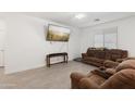 Living room featuring brown sofas, large TV, and wood-look floors at 19960 W Lilac St, Buckeye, AZ 85326