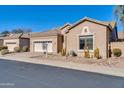 Tan house with a white garage door, desert landscaping, and neighboring homes visible at 4918 E Michigan Ave, Scottsdale, AZ 85254