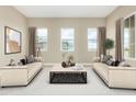 Spacious living room with two beige sofas, a coffee table, and large windows at 1 N Brenner Pass Rd, Queen Creek, AZ 85144