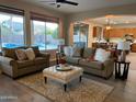 Inviting living room featuring plush sofas, an ottoman coffee table, and a view of the pool at 1923 E Zion Way, Chandler, AZ 85249