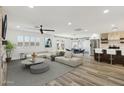 Bright living room boasts wood floors, neutral paint, a ceiling fan, modern kitchen, and access to the backyard at 2265 E Elmwood St, Mesa, AZ 85213